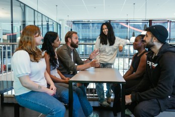 Foto av elever og veileder som snakker sammen.